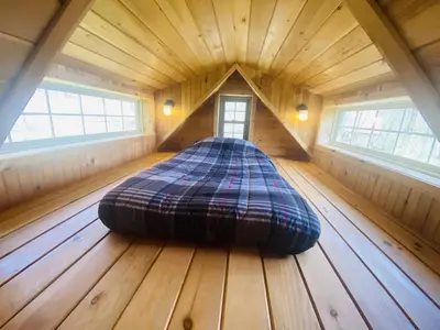 a large bed in a room in a wooden house at UndertheWillows by Towanda Sayre in Ulster