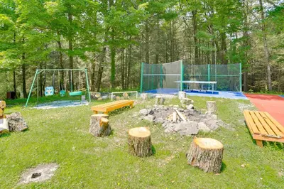 a park with a playground with benches and logs at 6 Mi to State Park Mongaup Valley Cabin! in Mongaup Valley