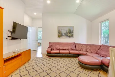 a living room with a brown leather couch and a flat screen tv at 6 Mi to State Park Mongaup Valley Cabin! in Mongaup Valley