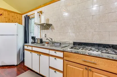 a kitchen with a stove and a white refrigerator at 5 Mi to Marina and Raceways Mongaup Valley Retreat! in Mongaup Valley