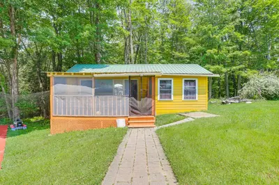 a yellow tiny house in the middle of a yard at 5 Mi to Marina and Raceways Mongaup Valley Retreat! in Mongaup Valley