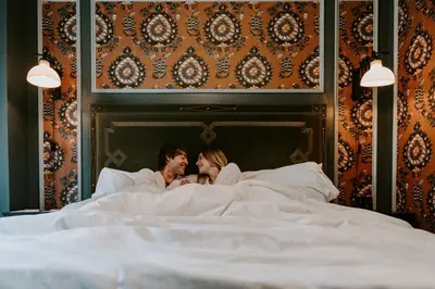 a man and a woman laying in bed at The Gas Lamp Hotel in Philadelphia