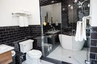 a bathroom with a toilet and a tub and a sink at The Gas Lamp Hotel in Philadelphia