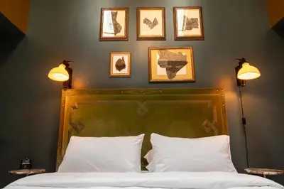 a bedroom with a bed with three pictures on the wall at The Gas Lamp Hotel in Philadelphia