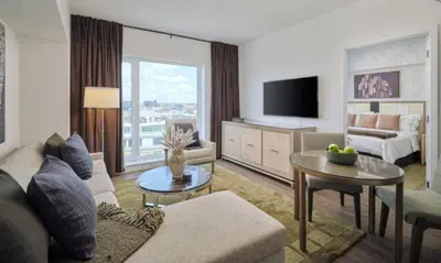 a living room with a couch and a room with a tv at Luxury Apartments by Hyatus at Central Philly in Philadelphia