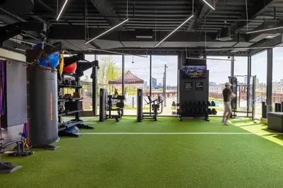 a gym with green flooring and a man in the gym at Luxury Apartments by Hyatus at Central Philly in Philadelphia