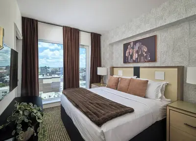 a bedroom with a large bed and a large window at Luxury Apartments by Hyatus at Central Philly in Philadelphia