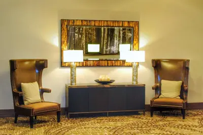 a lobby with two chairs and a table and a mirror at DoubleTree by Hilton Hotel Reading in Reading