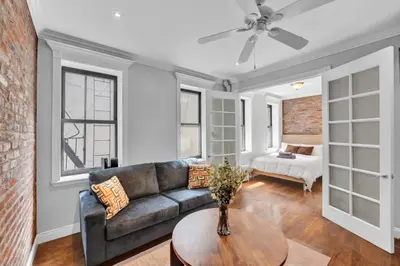 a living room with a couch and a bed at Stylish 3BR-2BA in Gramercy -Modern & Central in New York