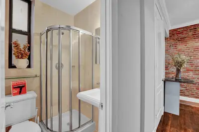 a bathroom with a shower with a toilet and a sink at Stylish 3BR-2BA in Gramercy -Modern & Central in New York