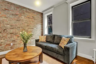 a living room with a couch and a table at Stylish 3BR-2BA in Gramercy -Modern & Central in New York
