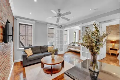 a living room with a couch and a table at Stylish 3BR-2BA in Gramercy -Modern & Central in New York