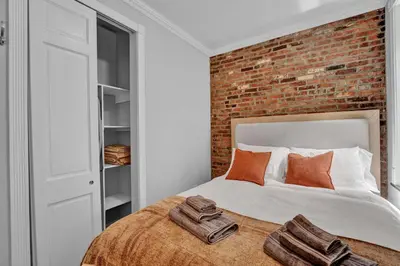 a bedroom with a bed with a brick wall at Modern 3BR in Gramercy -Near Union Sq NYU in New York