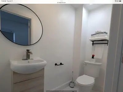 a bathroom with a sink and a toilet and a mirror at Sava apt rentals in Newark