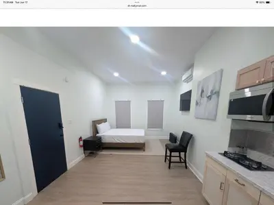 a living room with a bed and a kitchen at Sava apt rentals in Newark