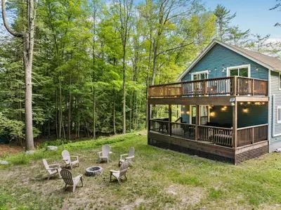 a house with a deck and chairs in the yard at Nature Getaway - Creek, Firepit, Deck, Privacy - Delaware River in Sparrow Bush