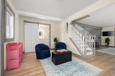 a living room with a staircase and blue chairs at Nature Getaway - Creek, Firepit, Deck, Privacy - Delaware River in Sparrow Bush