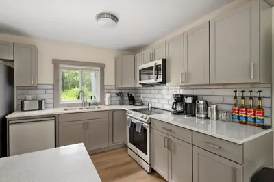 a kitchen with white cabinets and a counter top at Nature Getaway - Creek, Firepit, Deck, Privacy - Delaware River in Sparrow Bush