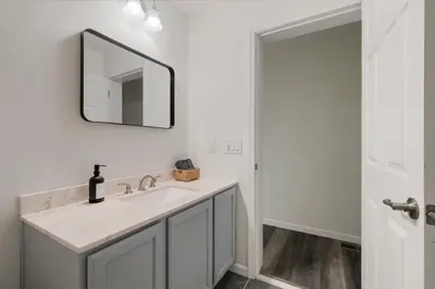 a white bathroom with a sink and a mirror at Upstate NY Escape - Game Ready, Game Room, Pool Table, Firepit, Delaware River in Sparrow Bush