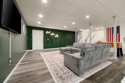 a living room with a couch and a flat screen tv at Upstate NY Escape - Game Ready, Game Room, Pool Table, Firepit, Delaware River in Sparrow Bush