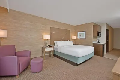 a hotel room with a bed and a couch at Holiday Inn Express & Suites New Cumberland by IHG in New Cumberland