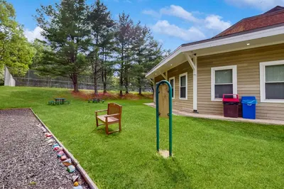 a yard with a sign and a chair in front of a house at Lounging in Long Pond in Long Pond