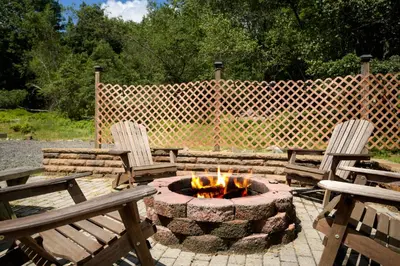 two chairs and a fire pit in a backyard at Lounging in Long Pond in Long Pond
