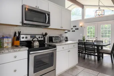a kitchen with white cabinets and a black stove top oven at Lounging in Long Pond in Long Pond