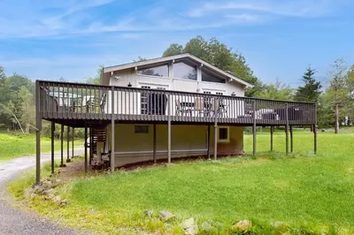 a house with a deck on the side of the road at Lounging in Long Pond in Long Pond