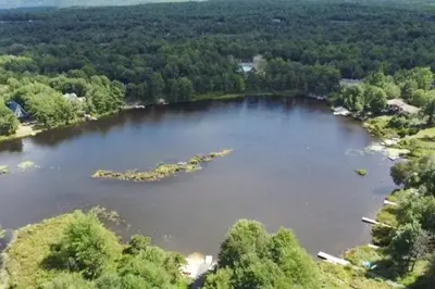 an aerial view of a large lake with trees at Lounging in Long Pond in Long Pond