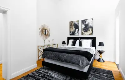 a bedroom with a black and white bed and a mirror at Studio in New York in Brooklyn