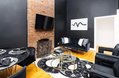 a living room with a fireplace and black walls at Studio in New York in Brooklyn
