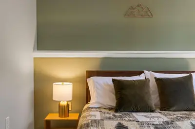 a bedroom with a bed and a lamp on a table at Cozy Lakefront Poconos Cabin Hot Tub Kayaks in Tobyhanna