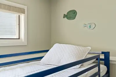 a bedroom with a bed with a fish on the wall at Cozy Lakefront Poconos Cabin Hot Tub Kayaks in Tobyhanna