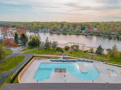 an overhead view of a swimming pool and a river at Cozy Lakefront Poconos Cabin Hot Tub Kayaks in Tobyhanna