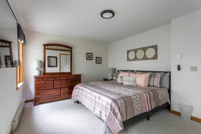 a bedroom with a bed and a dresser and a mirror at HOT TUB 4 Min Dr to Camelbeach in Tannersville