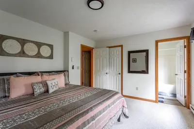 a bedroom with a large bed with pink pillows at HOT TUB 4 Min Dr to Camelbeach in Tannersville
