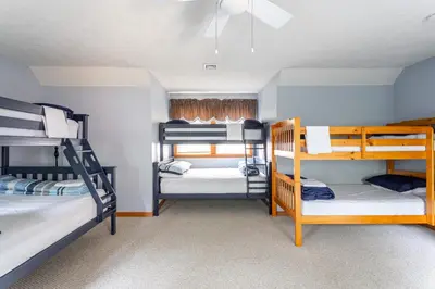 a room with three bunk beds in a house at HOT TUB 4 Min Dr to Camelbeach in Tannersville