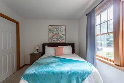 a bedroom with a bed and a window at HOT TUB 4 Min Dr to Camelbeach in Tannersville
