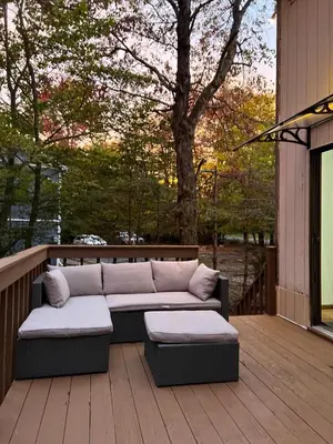 a couch on a wooden deck with a tree at Lovely tranquil spot for family and friends to gather in Tobyhanna