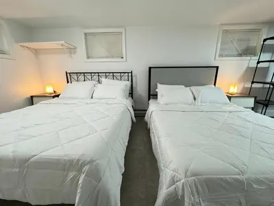 two beds in a room with white sheets at Open Serene Suite - 10mins-EWR, 25mins-NYC in Irvington