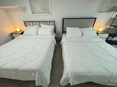 two beds sitting next to each other in a bedroom at Open Serene Suite - 10mins-EWR, 25mins-NYC in Irvington