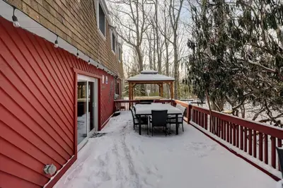 a deck with a table and chairs in the snow at Cozy mountain house with beach access and firepit in Lake Harmony