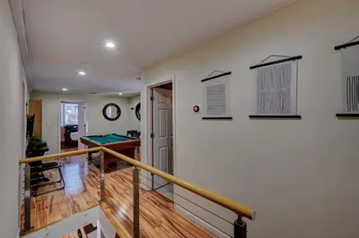 a room with a staircase with a ping pong table at Cozy mountain house with beach access and firepit in Lake Harmony