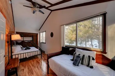 a bedroom with two beds and a large window at Cozy mountain house with beach access and firepit in Lake Harmony
