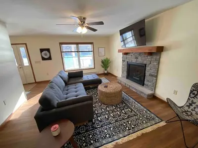 a living room with a couch and a fireplace at Lakefront home with kayaks fire pit hot tub and walk to restaurants and bars in Lake Harmony