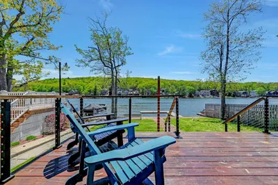two blue benches sitting on a boardwalk near the water at Lakefront home with kayaks fire pit hot tub and walk to restaurants and bars in Lake Harmony