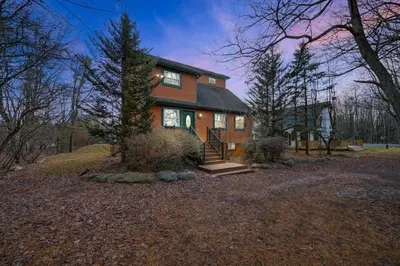 a house on a hill with a tree at Pocono Chalet Towamensing with Hot Tub Lake and Pool in Albrightsville