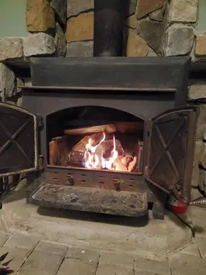 a stone oven with a fire in it at Pocono Chalet Towamensing with Hot Tub Lake and Pool in Albrightsville