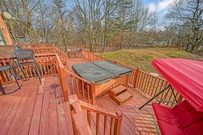 a wooden deck with a table and a hammock on it at Pocono Chalet Towamensing with Hot Tub Lake and Pool in Albrightsville
